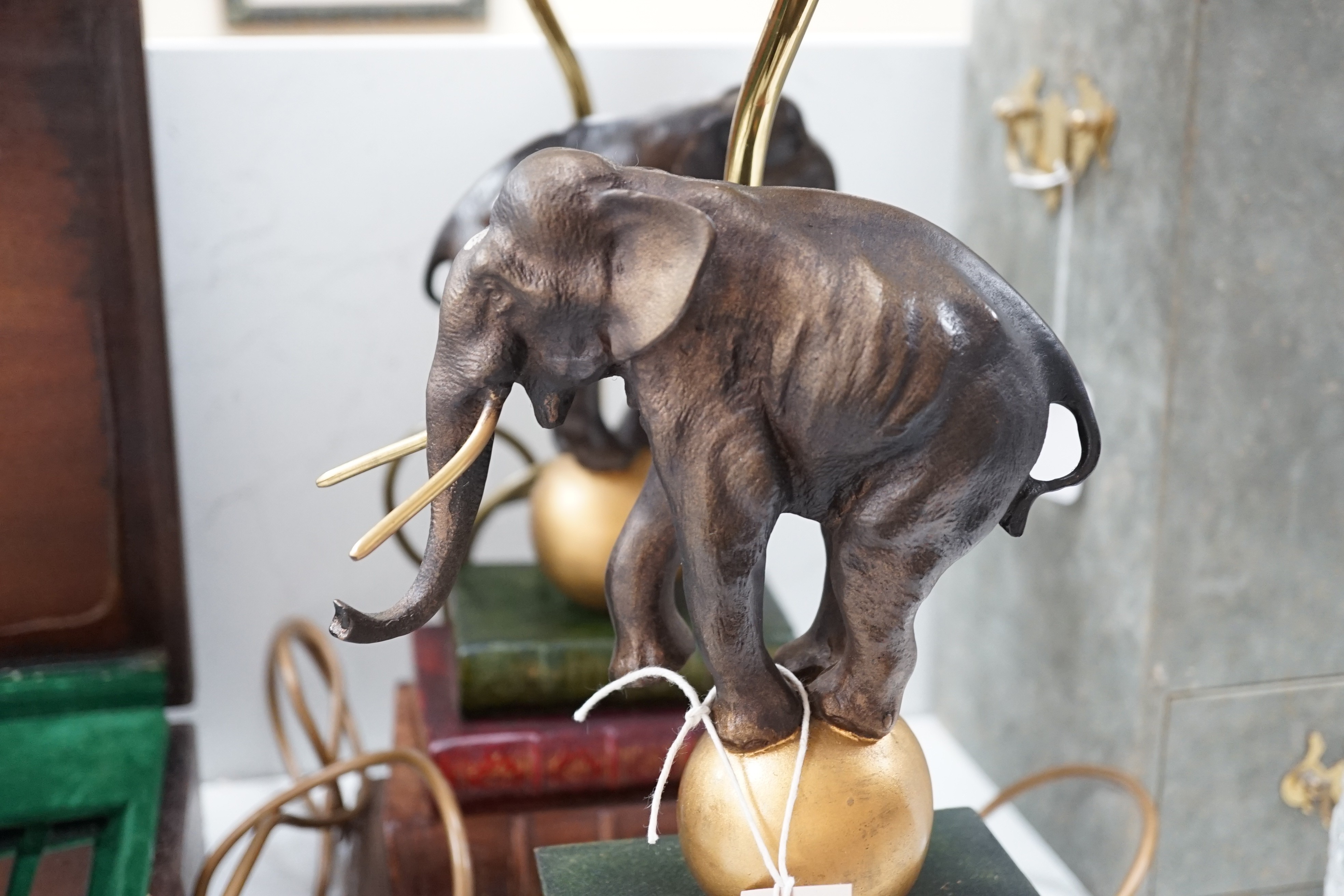 A pair of novelty table lamps: elephants balancing on balls on books, 63cms high